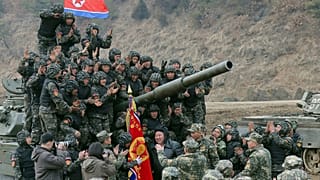 O líder norte-coreano Kim Jong Un, ao centro, encontra-se com soldados que participaram num treino na Coreia do Norte, 13 de março de 2024