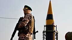 Un miembro de la Guardia Revolucionaria se para frente a un misil de fabricación iraní durante una marcha de las fuerzas de Basij en apoyo de los palestinos en Teherán, Irán, el viernes 24 de noviembre de 2023