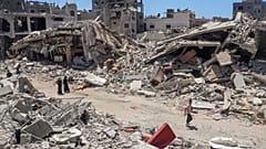 فلسطينيون يسيرون في الدمار الذي خلفه الهجوم الجوي والبري الإسرائيلي في جباليا شمال قطاع غزة في 30 مايو/أيار 2024