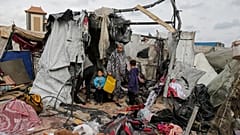  نازحون فلسطينيون يتفقدون خيامهم التي دمرها القصف الإسرائيلي، بجوار منشأة تابعة للأونروا غرب مدينة رفح، قطاع غزة، الثلاثاء، 28 مايو، 2024.