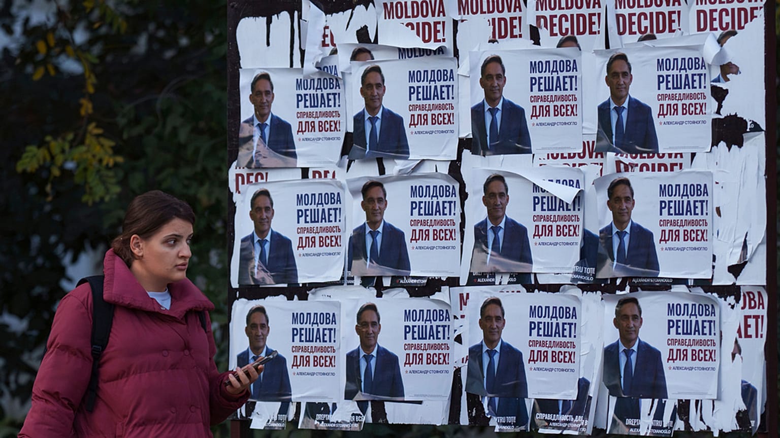 Kisinyovi járókelő Sztojanoglu választási plakátja előtt