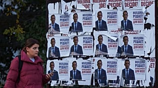 Une femme passe devant les affiches d'Alexandr Stoianoglo, candidat à la présidence du Parti socialiste de Moldavie (PSRM) à Chișinău, Moldavie, le vendredi 1er novembre 2024.