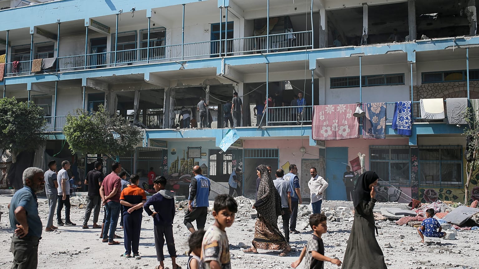 فلسطينيون ينظرون إلى آثار الغارة الإسرائيلية على مدرسة تديرها الأمم المتحدة والتي أودت بحياة العشرات في مخيم النصيرات للاجئين في قطاع غزة، الخميس 6 يونيو 2024