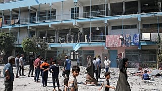 فلسطينيون ينظرون إلى آثار الغارة الإسرائيلية على مدرسة تديرها الأمم المتحدة والتي أودت بحياة العشرات في مخيم النصيرات للاجئين في قطاع غزة، الخميس 6 يونيو 2024