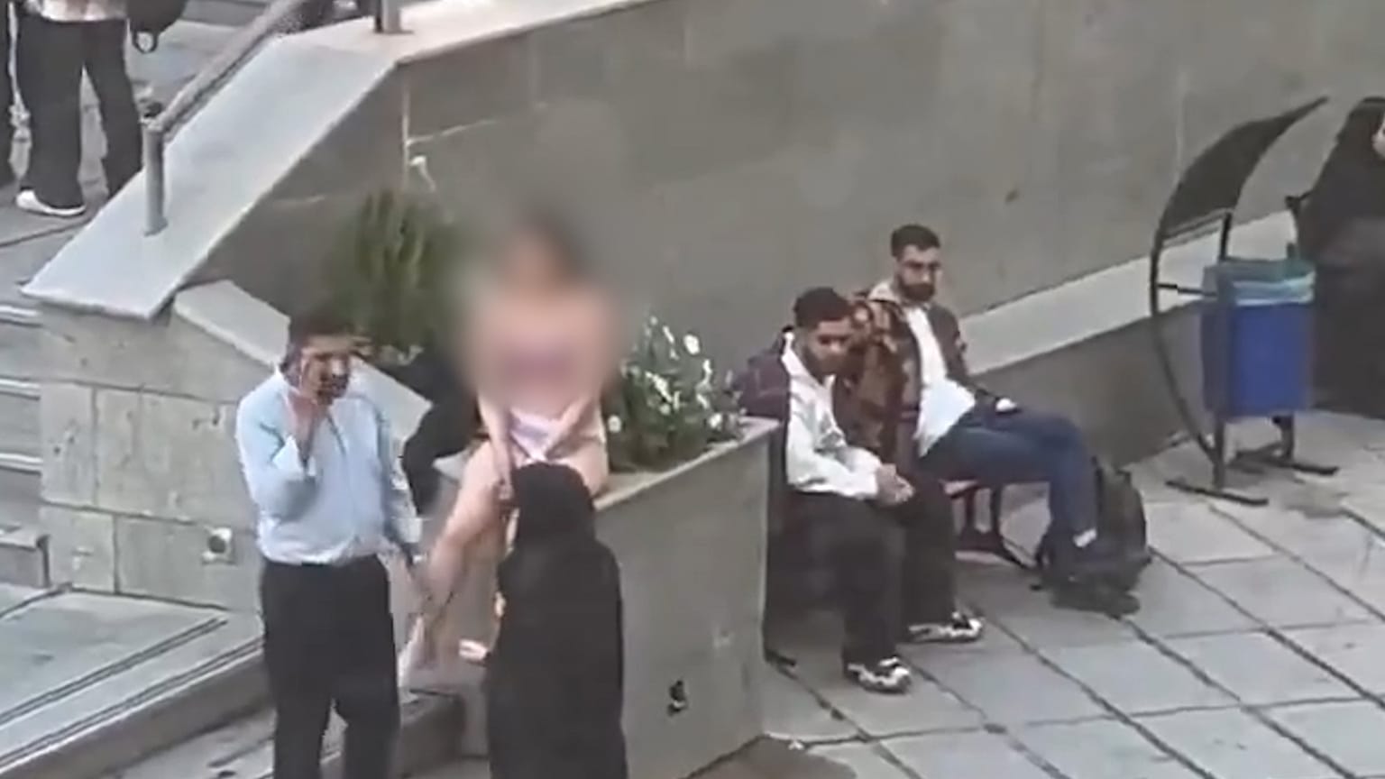 Vídeo que muestra a una estudiante en Irán junto a dos guardias de seguridad 
