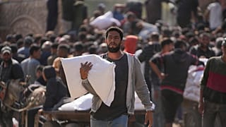 فلسطينيون يتجمعون لاستلام أكياس الطحين التي وزعتها الأونروا، وكالة الأمم المتحدة لمساعدة اللاجئين الفلسطينيين، في دير البلح، وسط قطاع غزة، السبت، 2 نوفمبر، 2024. 