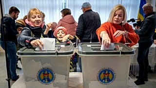 Des femmes déposent leur bulletin de vote dans un bureau de vote de la capitale Chișinău, 20 octobre, 2024.