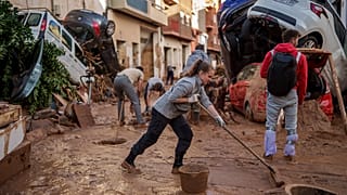 Emberek megtisztítják az utcát a sártól az árvíz sújtotta területen Paiportában, 2024. november 2.