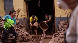 أشخاص ينظفون الطين من منزل متضرر من الفيضانات، في ألخميسي، إسبانيا، الأحد، 3 نوفمبر/تشرين الثاني 2024