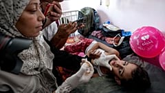 FOTO DE ARQUIVO: Um profissional de saúde administra uma vacina contra a poliomielite a uma criança num hospital em Khan Younis, sábado, 31 de agosto de 2024.