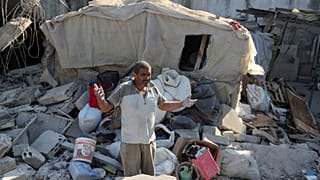 رجل وهو يقف على أنقاض مبنى أصيب في غارة جوية إسرائيلية في قرية العقبية بجنوب لبنان.