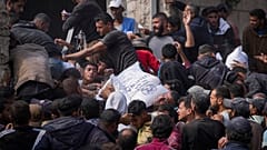 فلسطينيون يتجمعون لاستلام أكياس الطحين التي توزعها وكالة (الأونروا) في دير البلح وسط قطاع غزة، السبت، 2 نوفمبر/تشرين الثاني 2024.