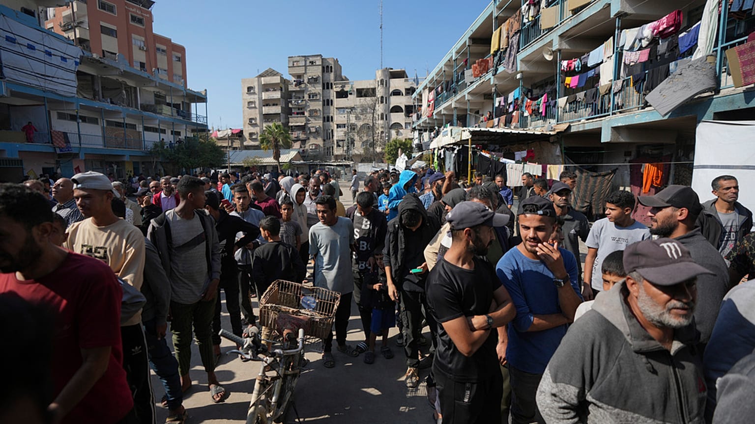 فلسطينيون يتجمعون لاستلام مساعدات توزعها وكالة (الأونروا) بمخيم النصيرات للاجئين الفلسطينيين في غزة، الثلاثاء، 5 نوفمبر/تشرين الثاني 2024.