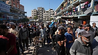 فلسطينيون يتجمعون لاستلام مساعدات توزعها وكالة (الأونروا) بمخيم النصيرات للاجئين الفلسطينيين في غزة، الثلاثاء، 5 نوفمبر/تشرين الثاني 2024.