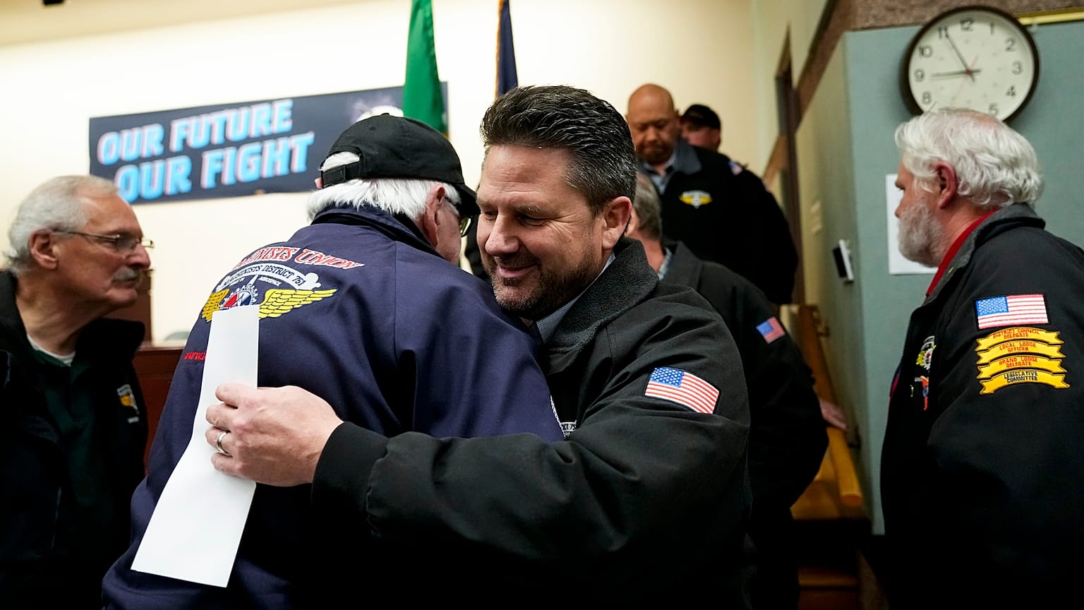 O líder sindical de Seattle, Jon Holden, cumprimenta os membros do sindicato depois de anunciar que tinham votado a favor de uma nova proposta de contrato da Boeing