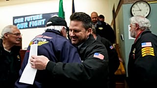 Il leader del sindacato di Seattle, Jon Holden, saluta i membri del sindacato dopo l'annuncio del voto per l'accettazione di una nuova offerta contrattuale da parte di Boeing