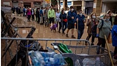Residents wait to receive drinking water in an area, affected by floods, in Paiporta, Valencia.