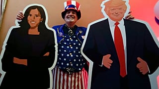 Сотрудник Генконсульства США в Милане позирует с картонными фигурами Харрис и Трампа 