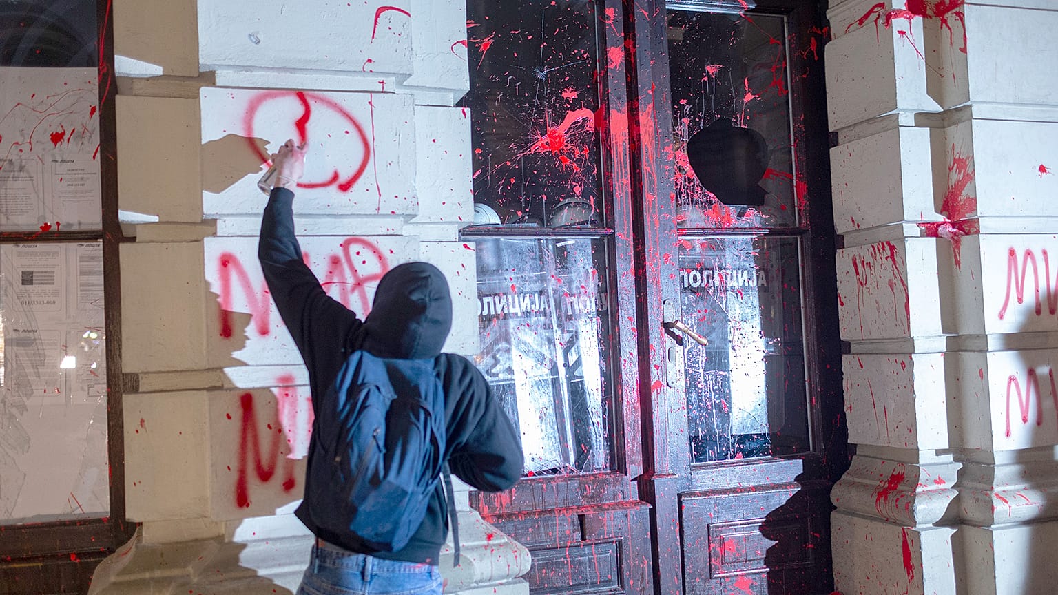 Novi Sad'da bir tren istasyonunun çatısının çökmesi üzerine ölen kişiler için düzenlenen gösteride bir protestocu belediye binasına grafiti çizdi, 5 Kasım 2024