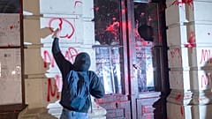 Novi Sad'da bir tren istasyonunun çatısının çökmesi üzerine ölen kişiler için düzenlenen gösteride bir protestocu belediye binasına grafiti çizdi, 5 Kasım 2024