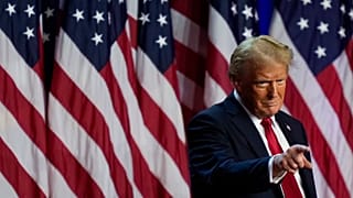 O candidato presidencial republicano, o antigo Presidente Donald Trump, aponta para a multidão numa festa de observação da noite eleitoral, a 6 de novembro de 2024, em West Palm Beach, Florida.