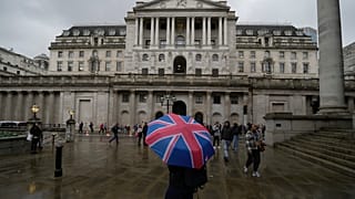 A woman holding an umbrella stands outside the Bank of England