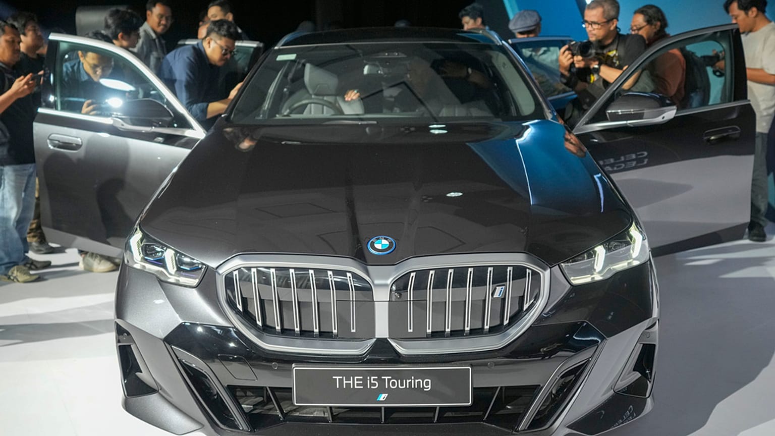 Gazeteciler, Endonezya'nın başkenti Cakarta'da düzenlenen lansman etkinliği sırasında BMW i5 Touring elektrikli otomobilin içini inceliyor, 18 Eylül 2024