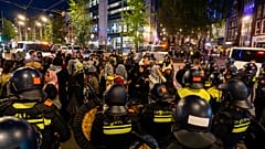 Festgenommene pro-palästinensische Demonstranten warten darauf, nach einer pro-israelischen Gedenkveranstaltung zum Jahrestag des Hamas-Anschlags vom 7. Oktober 2023 in Amsterdam mit Bussen weggebracht zu werden.