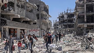 فلسطينيون يسيرون وسط الدمار في أعقاب هجوم جوي وبري إسرائيلي في جباليا، شمال قطاع غزة، في 30 مايو 2024.