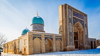 Украшенный вход и два купола комплекса Хазрати Имам, религиозного центра Ташкента, зимой в Узбекистане