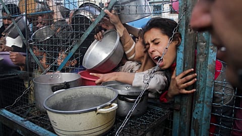 Palestinians line up to receive meals in the Jabaliya refugee camp, 18 March, 2024