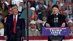 El candidato presidencial republicano, el ex presidente Donald Trump, escucha mientras Elon Musk habla durante un mitin de campaña en el Butler Farm Show, el sábado 5 de octubre de 2024, en Butler, P