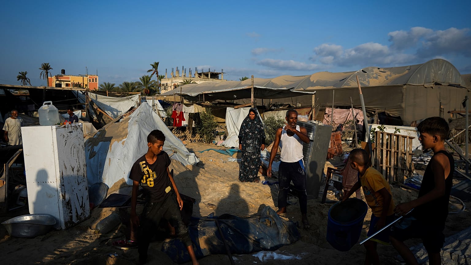 فلسطينيون ينظرون إلى الدمار الذي خلفته غارة جوية إسرائيلية على مخيم مكتظ بالنازحين الفلسطينيين في المواصي، قطاع غزة، الثلاثاء 10 سبتمبر/أيلول 2024