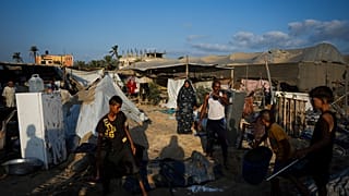 فلسطينيون ينظرون إلى الدمار الذي خلفته غارة جوية إسرائيلية على مخيم مكتظ بالنازحين الفلسطينيين في المواصي، قطاع غزة، الثلاثاء 10 سبتمبر/أيلول 2024