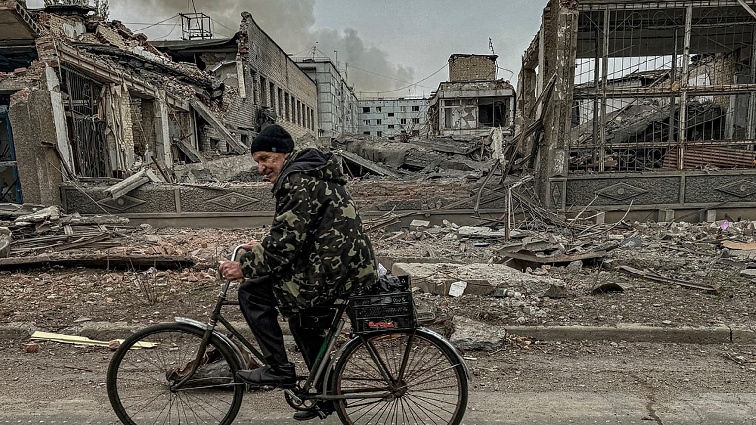 Un hombre monta en bicicleta frente a la oficina de correos destruida por un ataque aéreo ruso en Kurájove