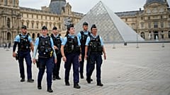 A polícia francesa patrulha uma praça perto do Louvre, em Paris, antes da cerimónia de abertura dos Jogos Olímpicos de verão de 2024, 26 de julho de 2024