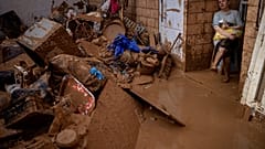 Woman looks down at belongings ruined after devastating flash floods hit parts of Spain