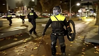 En esta imagen tomada de un video, agentes de Policía patrullan con equipo antidisturbios en las calles de Ámsterdam, el lunes 11 de noviembre de 2024.