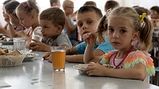 Niños de un orfanato de la región de Donetsk, comen en un campamento de Zolotaya Kosa, el asentamiento en el Mar de Azov, región de Rostov, suroeste de Rusia.