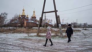 Alina Soboleva, 9 ans, marche avec sa grand-mère, Svitlana Lokotosh, pour participer à un événement organisé à l'occasion de la Saint-Nicolas à Izium, en Ukraine, 6.12.24