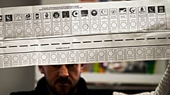 Bu fotoğrafta Türkiye'deki yerel seçimlerde bir sandık görevlisinin oy pusulasını tuttuğu görülüyor, 31 Mart 2024