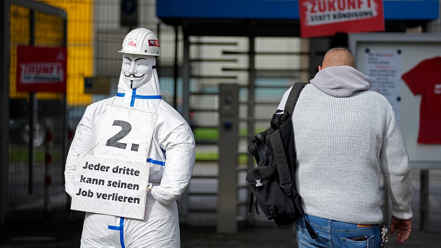 Egy munkás belép a thyssenkrupp acélgyárba a németországi Duisburgban, 2024. október 8-án, kedden, az IG Metall acélszakszervezet táblája mellett, amelyen az áll: "minden harmadik elveszítheti a munkáját".