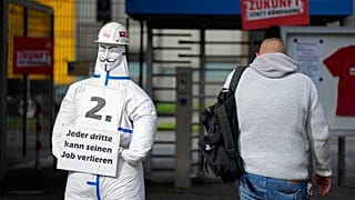 Ein Arbeiter betritt das thyssenkrupp Stahlwerk in Duisburg, Deutschland, Dienstag, 8. Oktober 2024, neben einem Schild der IG Metall mit der Aufschrift "Jeder Dritte kann seinen Job verlieren".