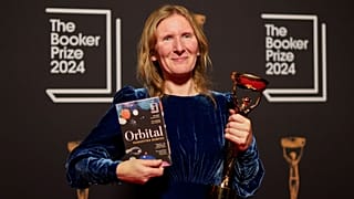 Samantha Harvey poses with the trophy and her book "Orbital" after winning the Booker Prize award 2024, in London.