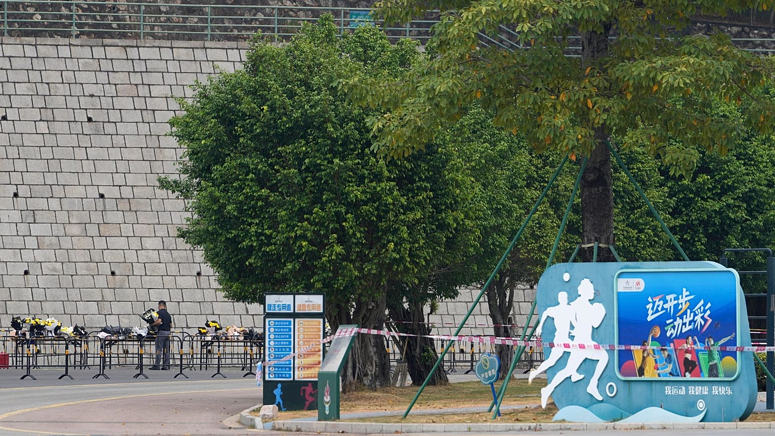 I volontari riposizionano i fiori deposti all'esterno della "Zhuhai People's Fitness Plaza" mercoledì 13 novembre 2024.