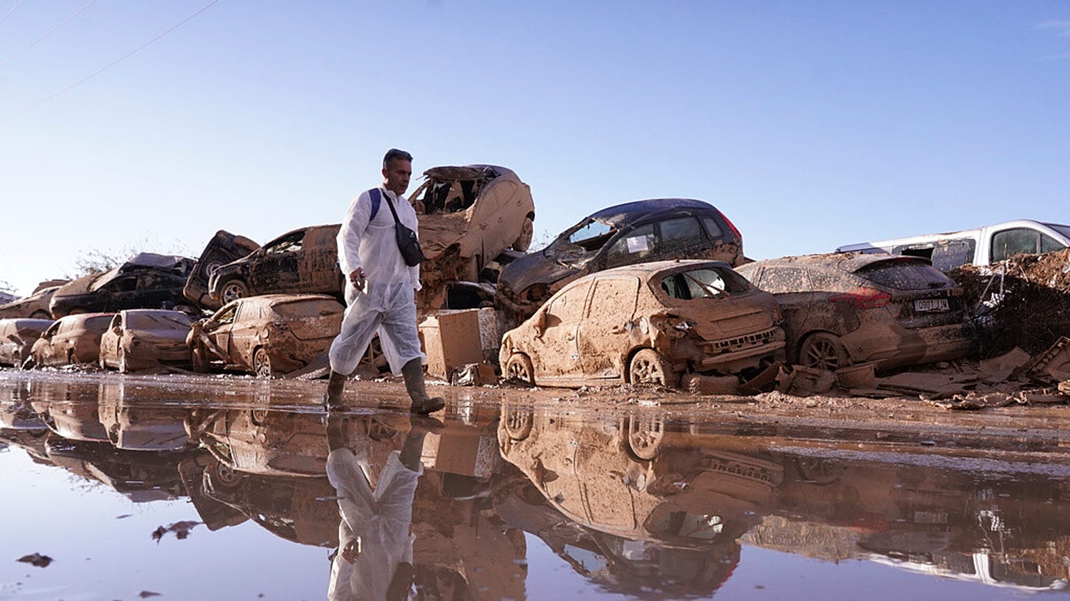 DOSSIER : Un homme passe devant des voitures empilées après les inondations de Catarroja qui ont fait des centaines de morts et de disparus dans la région de Valence en Espagne, mardi 12 novembre 2024.