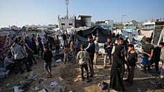  فلسطينيون يتجمعون في موقع الغارة الإسرائيلية في باحة مستشفى الأقصى حيث يعيش النازحون في خيام، في دير البلح بقطاع غزة، في 9 نوفمبر/تشرين الثاني 2024