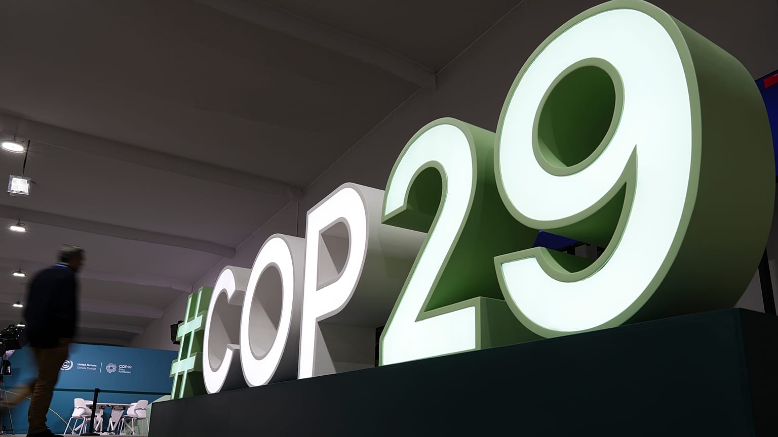 An attendee walks near a sign for the COP29 U.N. Climate Summit, Saturday, Nov. 9, 2024, in Baku, Azerbaijan. 