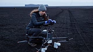 10. A estudante de doutoramento Polly Foster muda os diapositivos colocados no drone, à medida que são recolhidas várias medidas a diferentes alturas no deserto de Myrdalssandur.