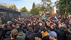 In this photo taken from video released by AIASHARA Independent Agency, Protesters gather outside the parliament building of the Georgian separatist region of Abkhazia 